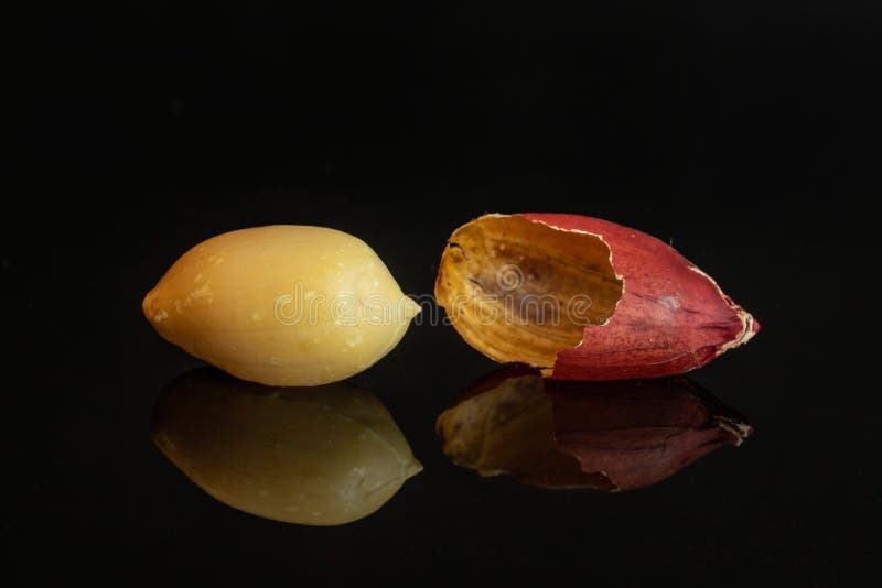 Yellow natural peanut isolated on black glass