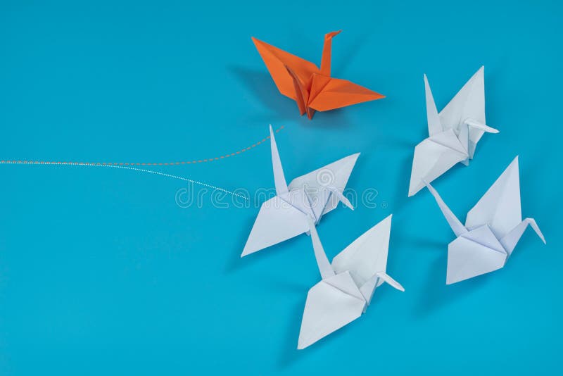 Group of Origami Cranes with One of Them Going into a Different Way