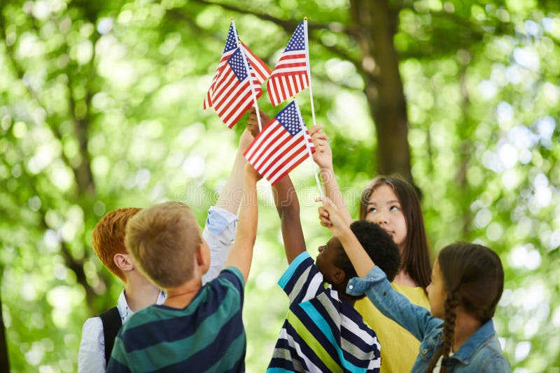 Children raising us stick flags together royalty free stock images