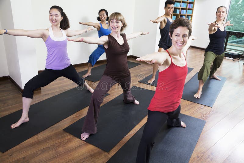 Group Of People With Arms Outstretched Doing Yoga During A Yoga Class 