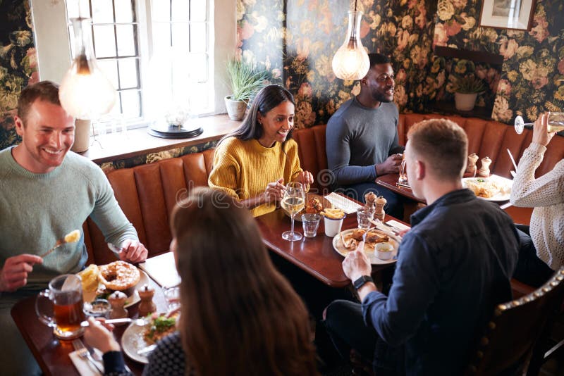 Group Of People Eating In Restaurant Of Busy Traditional English Pub royalty free stock photos