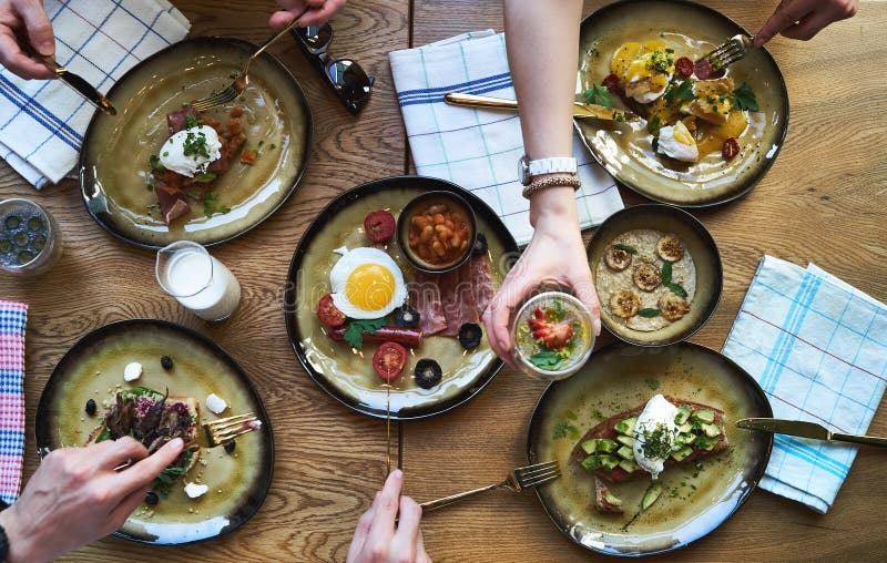 Group of people having breakfast and sitting at table, top view stock image Group of people having breakfast and sitting at table, top view stock image