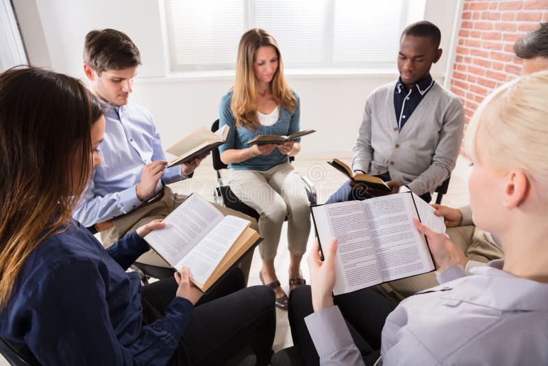 Gruppo Di Persone Sedute Sulle Sedie In Cerchio Lettura Della Bibbia.