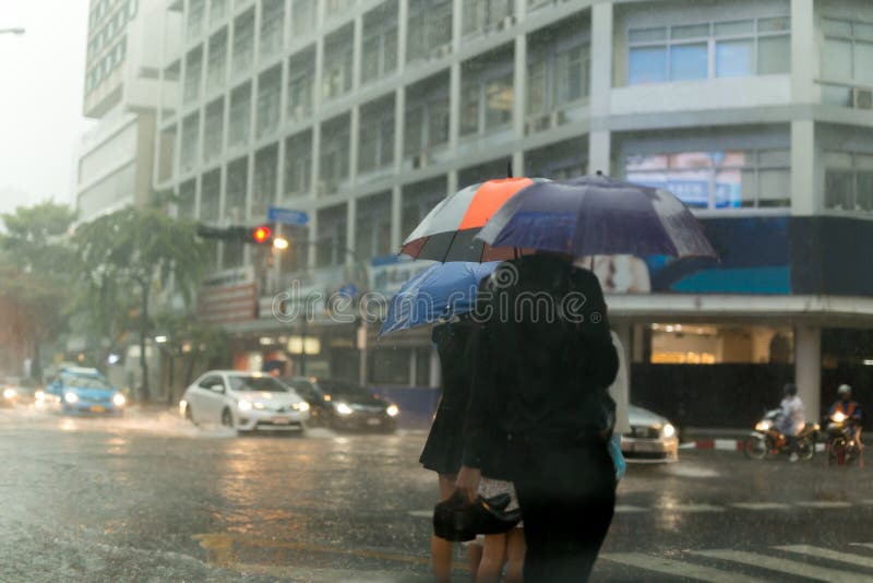 Group of people with umbrella crossing the road in the rain