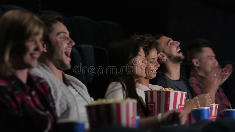 A group of people watching a movie showing emotion