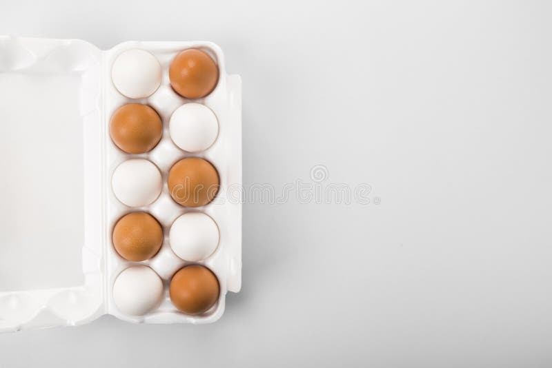 Group of raw eggs white and brown. Concept of diversity, isolation, racism, inequality. On gray background stock images