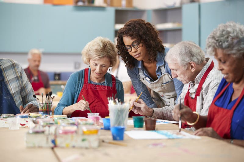 Group Of Retired Seniors Attending Art Class In Community Centre With Teacher stock image Group Of Retired Seniors Attending Art Class In Community Centre With Teacher stock image