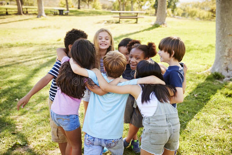 A group of school kids in a huddle outdoors, back view. Happy multiethnic boys stock images, royalty-free photos and pictures