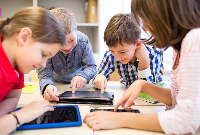 L'educazione, la scuola elementare, l'apprendimento, la tecnologia e la gente concetto di gruppo di bambini della scuola con i tablet pc computer divertirsi a rompere in aula.