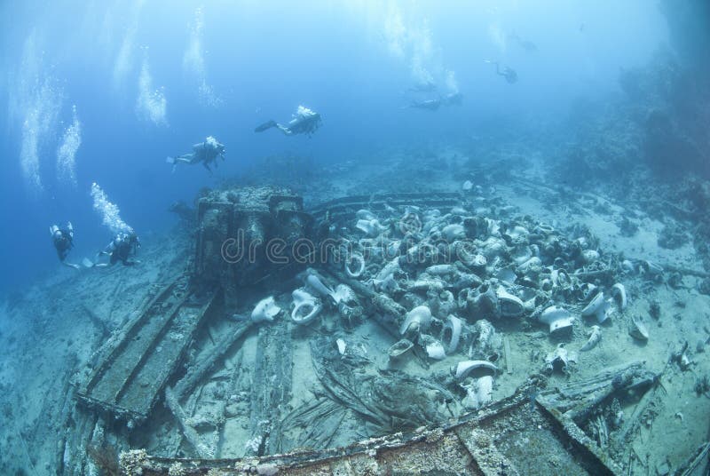 Group of scuba divers exploring a shipwreck.