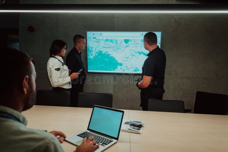 Group of Security data center operators working in a CCTV monitoring room looking on multiple monitors Officers stock images