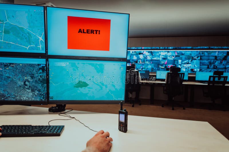 Group of Security data center operators working in a CCTV monitoring room looking on multiple monitors. Officers stock photography