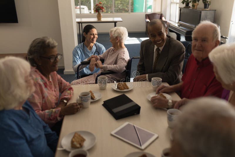 Group of Senior Friends Having Breakfast on Dining Table at Nursing
