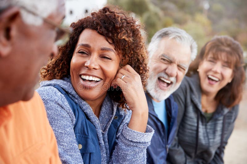 Group Of Senior Friends On Hike In Countryside Talking And Laughing Together royalty free stock images