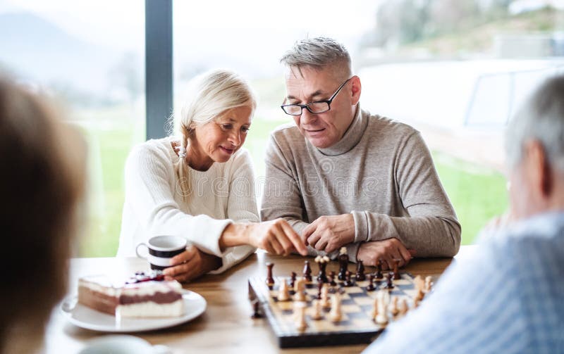 Group of senior friends at home, playing board games. Group of happy senior friends at home, playing board games stock photos