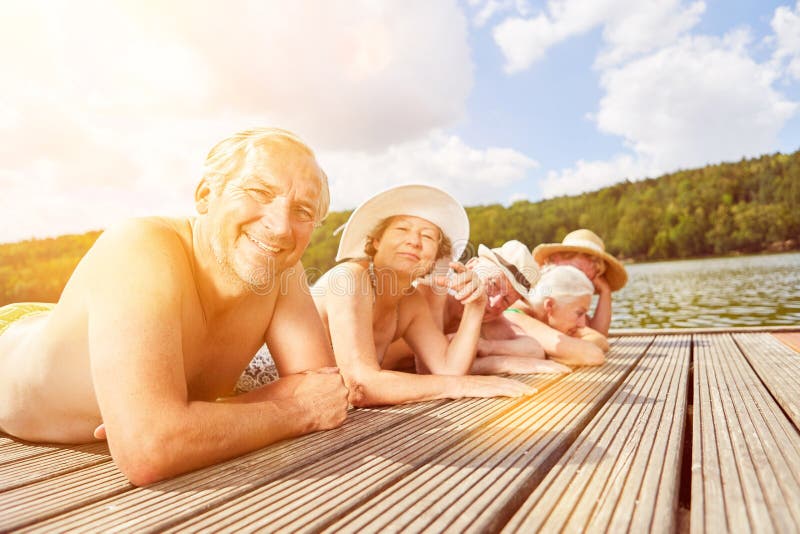 Group of seniors sunbathing by the lake royalty free stock photography Group of seniors sunbathing by the lake royalty free stock photography