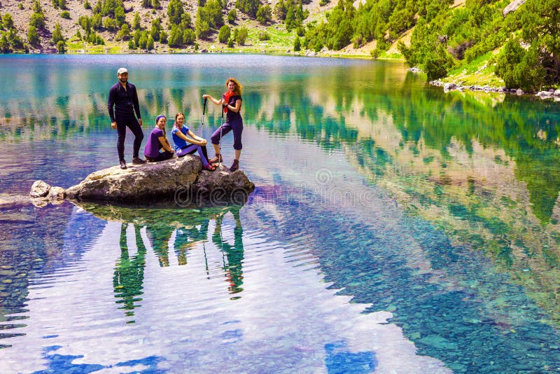Group of smiling Hikers on rock at Mountain Lake royalty free stock photo Group of smiling Hikers on rock at Mountain Lake royalty free stock photo