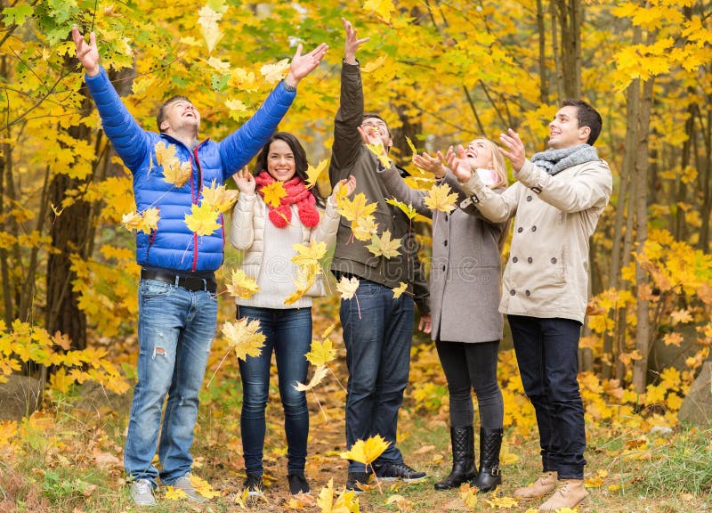 Group of smiling men and women in autumn park