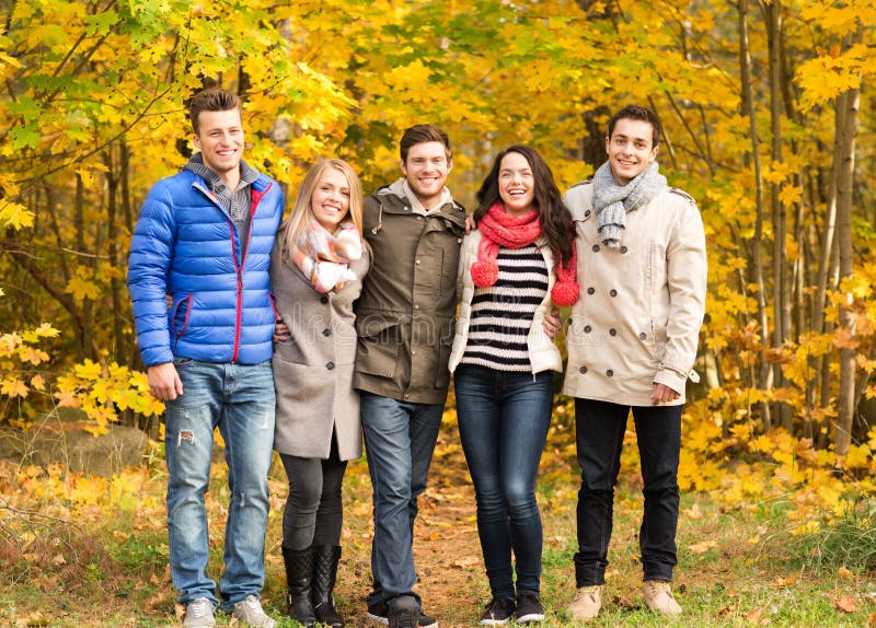 Group of smiling men and women in autumn park