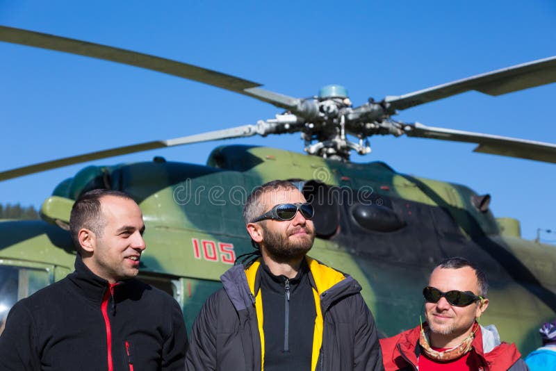 Group of Smiling Mountain Climbers Arrived to Exotic Destination by Helicopter stock photo Group of Smiling Mountain Climbers Arrived to Exotic Destination by Helicopter stock photo