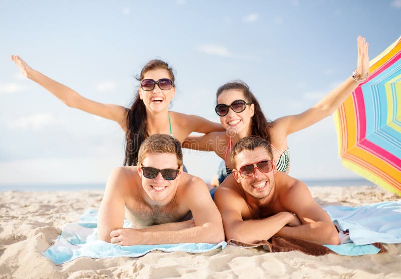 Estate, vacanze, vacanza e le persone felici concetto di gruppo di persone sorridenti in occhiali da sole divertirsi sulla spiaggia.