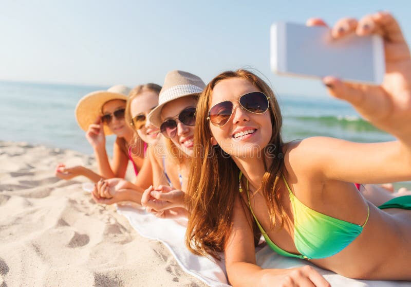 Group of smiling women with smartphone on beach royalty free stock images Group of smiling women with smartphone on beach royalty free stock images