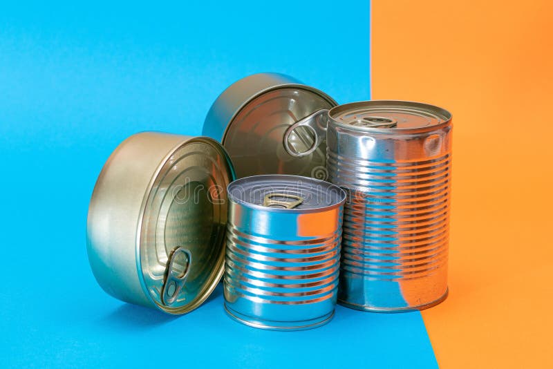 A Group of Stacked Tin Cans with Blank Edges on Split Blue and Orange Background Stock Image