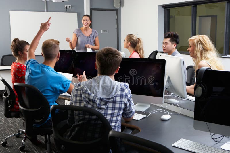 Group Of Students With Female Tutor In Computer Class