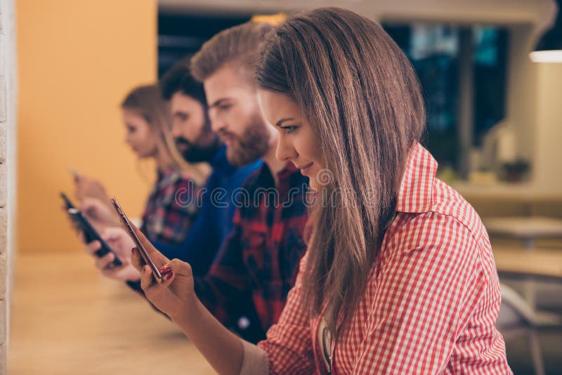 Group of students typing messages on smartphones to friends royalty free stock photos