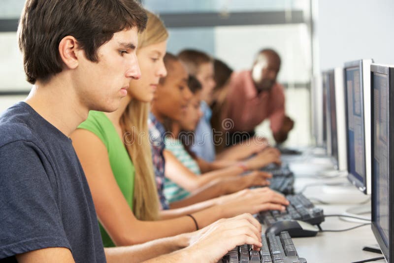 Group Of Students Working At Computers In Classroom