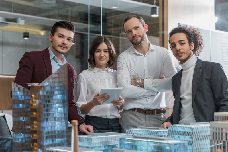 Group of Successful Architects Standing Next To Building Models Stock