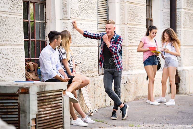 Group of teenage students talking in front of university. stock photo Group of teenage students talking in front of university. stock photo