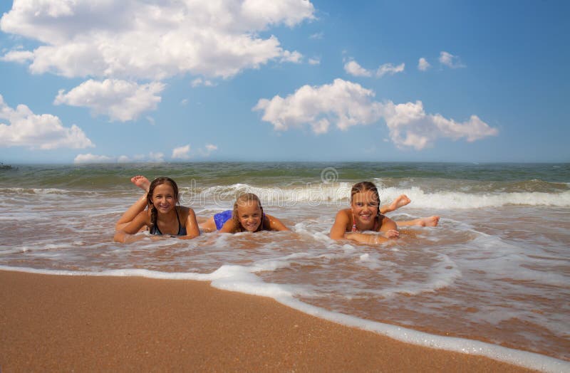 Group of three beautiful teen girl on the beach