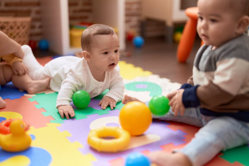 Group of Toddlers Playing with Toys Crawling on Floor at Kindergarten