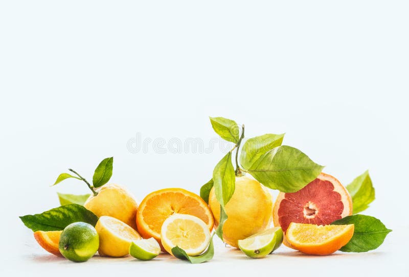 Group of various citrus fruits with juice splash at white background. Oranges, grapefruit, lime and lemon with green leaves. Slices, halves and quarters of fruits. Healthy food and drinks concept