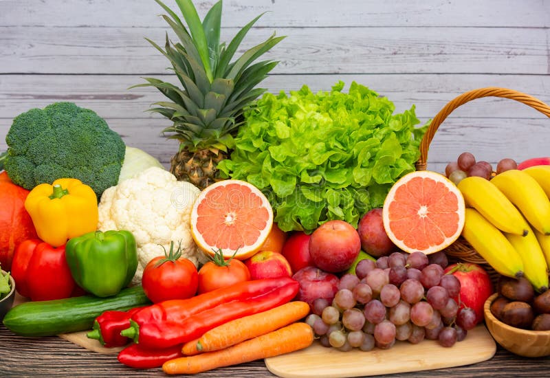 Group vegetables and Fruits Apples, grapes, oranges, and bananas in the wooden basket with carrots, tomatoes, guava, chili, eggpla