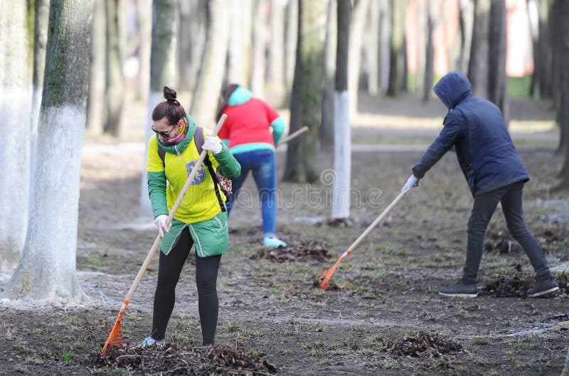 Group of the volunteers picking up litter in the park stock photos Group of the volunteers picking up litter in the park stock photos