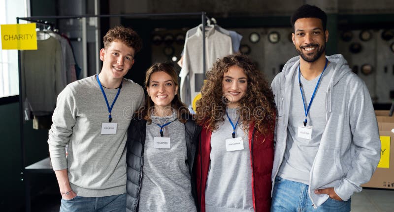 A group of volunteers at work in community charity donation center, looking at camera. Charity sorting stock images, royalty-free photos and pictures