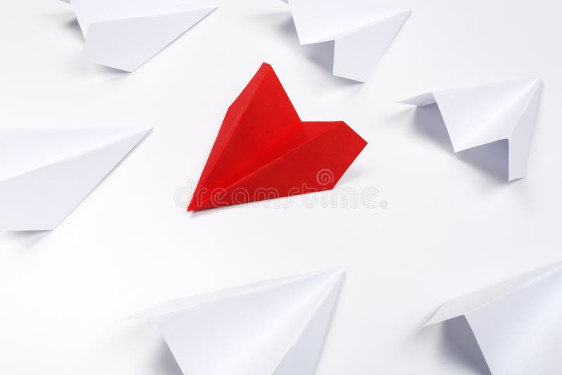 Group Of White Paper Plane In One Direction And One Red Paper Plane Pointing In Different Way On White Background. Business For