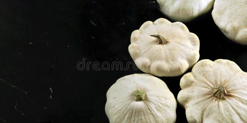 Group of white pattypan squash on black board, space for text left side royalty free stock photography Group of white pattypan squash on black board, space for text left side royalty free stock photography