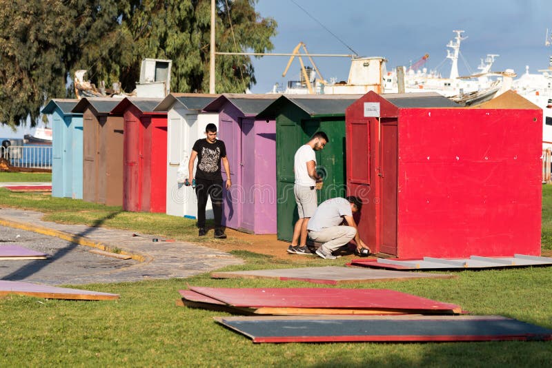 A group of workers - carpenters building plywood cabins with battery drills outdoors on a grass in Heraklion, Greece stock image A group of workers - carpenters building plywood cabins with battery drills outdoors on a grass in Heraklion, Greece stock image