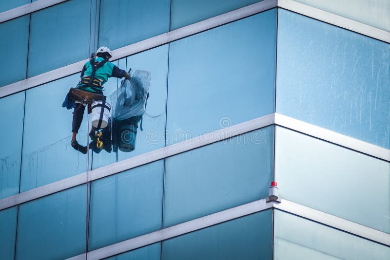 Grupo de trabajadores limpieza ventanas servicio sobre el alto crecimiento edificios.