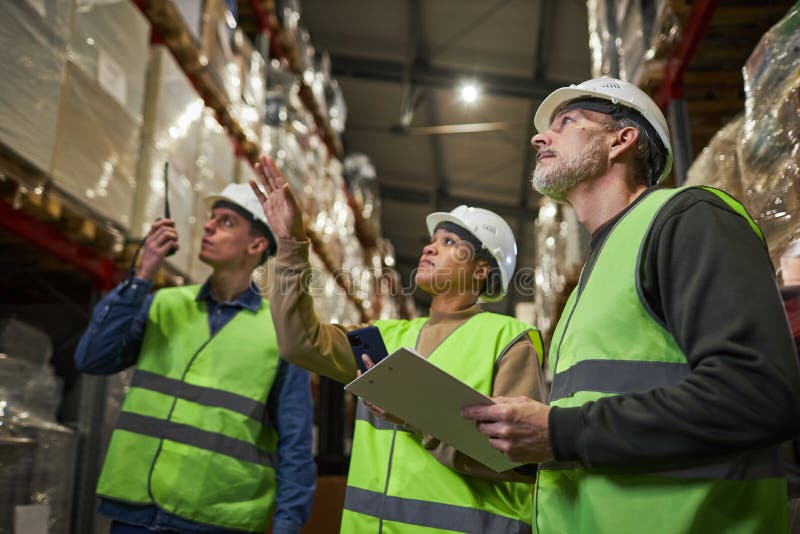 Group of Workers in Warehouse Doing Stock Review Storage Management