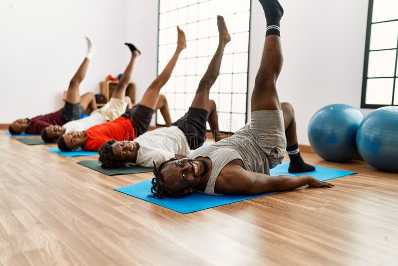 Group of Young African American Man Training Abs Exercise at Sport