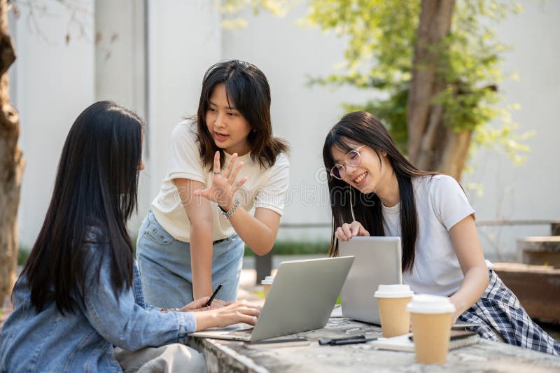 A group of young Asian female college students is focused on discussing a project royalty free stock image