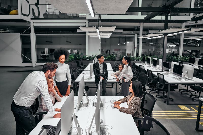 A group of young business people working in a spacious office with lots of computers. Developers, programming, online business royalty free stock image