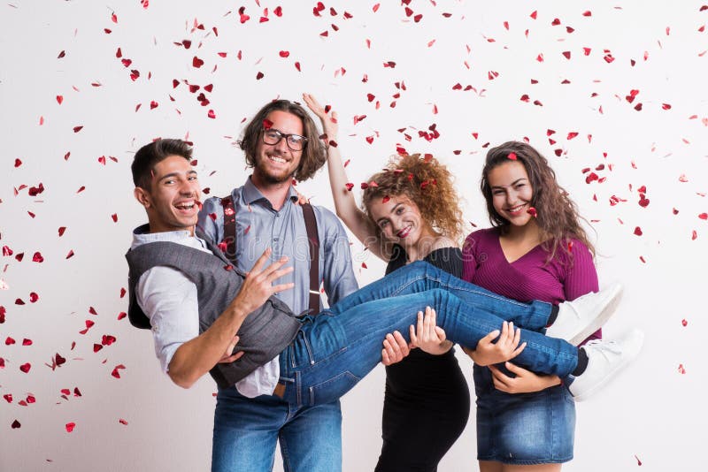 A group of young people holding a friend in a studio, enjoying a party. royalty free stock photo A group of young people holding a friend in a studio, enjoying a party. royalty free stock photo