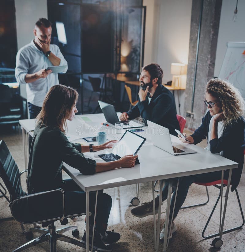 Group of young coworkers work together modern coworking studio.Young people making conversation with partners at the royalty free stock photo Group of young coworkers work together modern coworking studio.Young people making conversation with partners at the royalty free stock photo