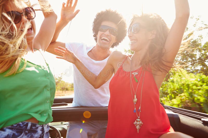 Group Of Young Friends Dancing In Back Of Open Top Car stock images