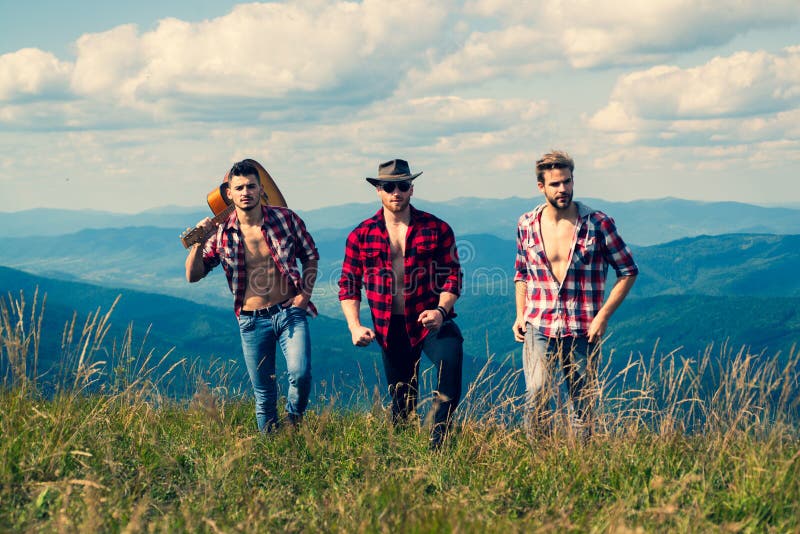 Group of young friends hiking in countryside. Three men walking by hiking trail. Three Friends Travel and Adventure stock image Group of young friends hiking in countryside. Three men walking by hiking trail. Three Friends Travel and Adventure stock image